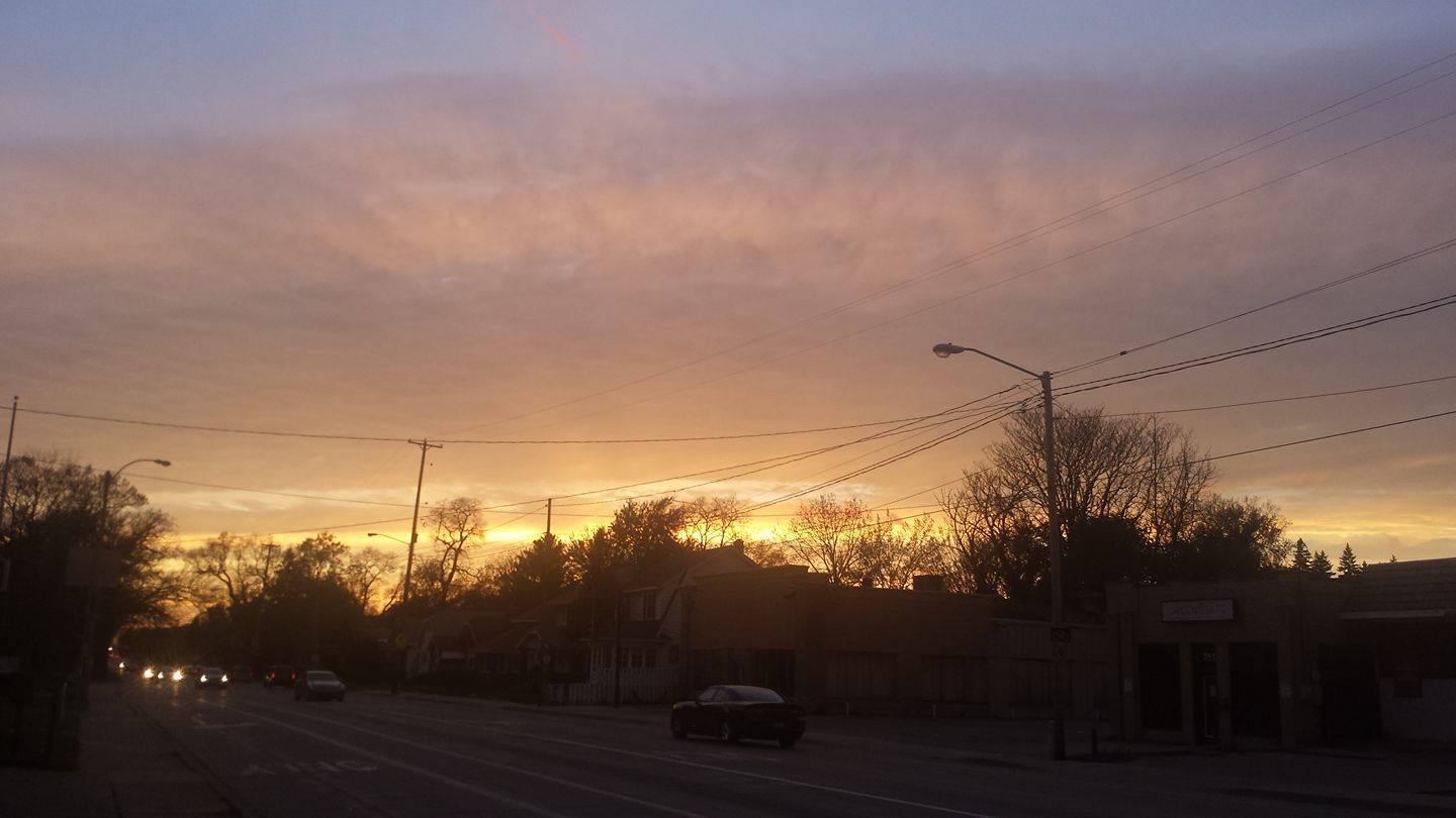 Cloudy sunset over a street with stores